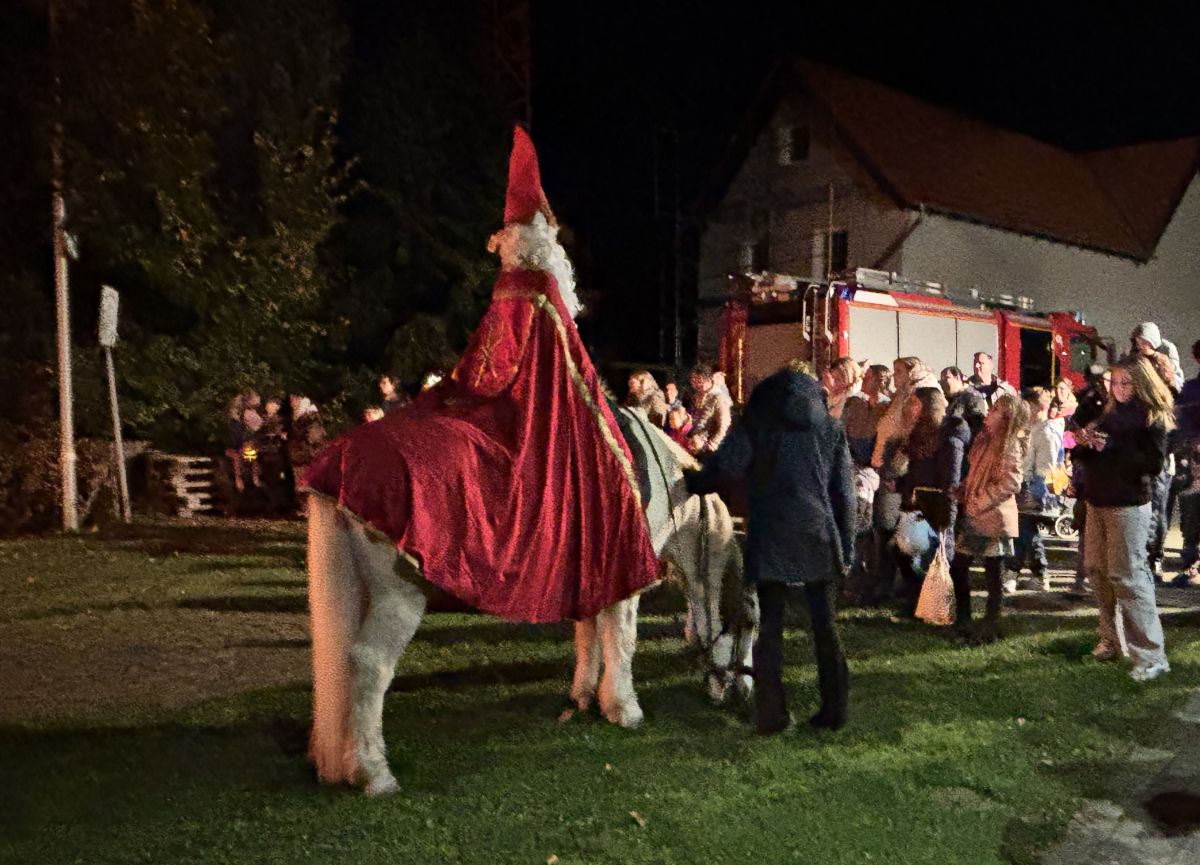 St. Martin auf einem Pferd und Kinder mit Laternen. Im Hintergrund das LF20.