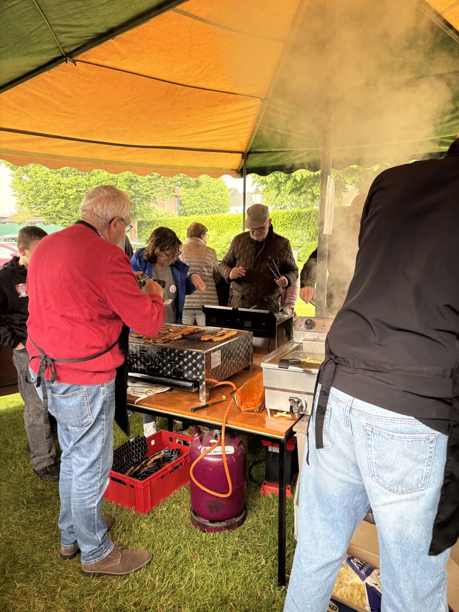 Menschen beim Grillen von Fleisch und Frittieren