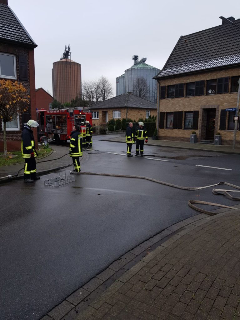 Wasserversorgung auf Straße mit Feuerwehrfahrzeug im Hintergrund