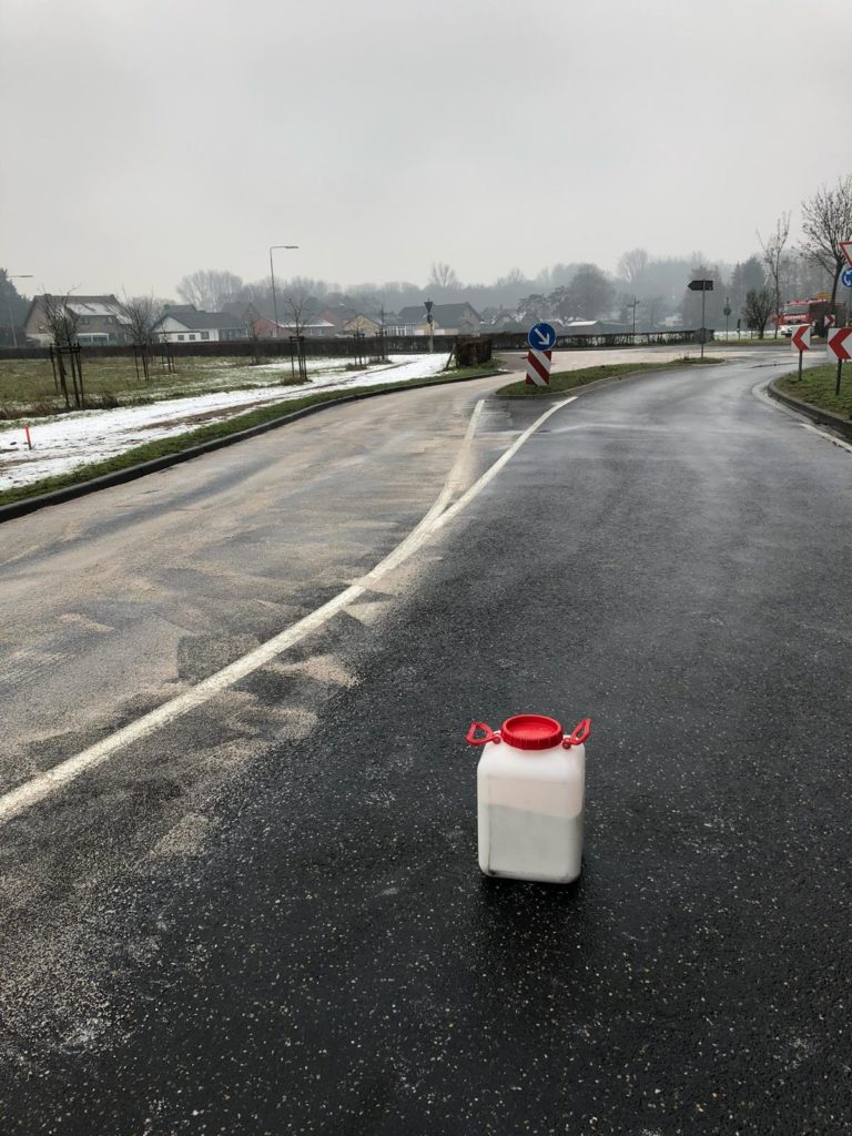 abgestreute Straße mit Bindemittelgefäß
