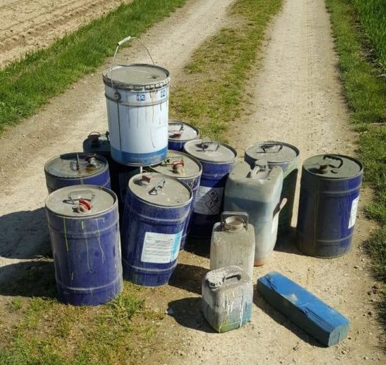 mehrere Ölfässer auf einem Feldweg